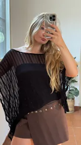 Capa de hilo negra con diseño de hombros descubiertos, mangas anchas y acampanadas, y textura de rayas verticales.