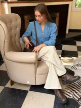 Cartera bandolera de cuero color chocolate, con solapa frontal decorada con costuras artesanales a la vista. Cuenta con correa larga ajustable y herrajes metálicos en tono bronce.