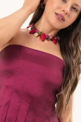 Top strapless de tafeta en color bordó, con recortes verticales y diseño estructurado de tablas en la parte inferior que aportan volumen.
