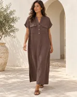 Vestido camisero largo de lino color blanco, con cuello en V, mangas cortas con vuelta y bolsillos frontales con solapa. Cuenta con cierre de botones en la parte superior.