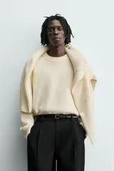 Jersey de punto con textura efecto pelo, corte relajado, cuello redondo y manga larga con acabados en rib.