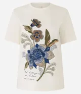 Blusa slim de mangas cortas, confeccionada en algodón, con cuello redondo y estampa floral con lettering caligráfico.