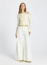 Remera de punto acanalado color beige, de corte ajustado, con escote asimétrico con detalle de tiras drapeadas y mangas largas.