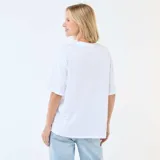 Camiseta de corte oversize color blanco, con cuello redondo y mangas cortas. Presenta un estampado frontal con la inscripción 'Beverly Hills L.A. 1989 West Co' en tonos azules.