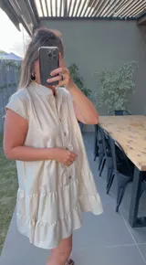 Vestido corto de lino con lurex, con cuello mao, mangas cortas y falda escalonada con volantes.