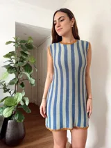 Vestido corto de algodón tejido en punto jersey con diseño de rayas verticales rojas y blancas. Terminaciones en crochet hechas a mano con detalle de lurex. Cuello redondo, sin mangas y silueta trapecio.