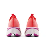 Championes de running New Balance modelo FuelCell SuperComp Elite, color naranja vibrante con detalles en blanco y violeta. Presentan entresuela con tecnología FuelCell y Energy Arc, empeine de tejido de punto sin costuras y placa de fibra de carbono.