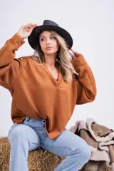 Sweater de punto color marrón con cuello en V y mangas largas.