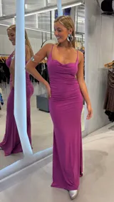 Vestido largo fucsia con escote drapeado, tirantes finos y detalles de fruncidos laterales a lo largo del cuerpo.