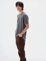 Pantalón tipo cargo confeccionado en tela de brim de algodón color azul marino. Presenta un diseño de calce holgado (baggy) con costuras en contraste de color naranja y bolsillos laterales funcionales.