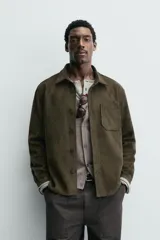 Sobrecamisa de corte regular confeccionada en tejido con efecto ante. Presenta cuello solapa, cierre frontal con botones, mangas largas con puños abotonados y un bolsillo de plastrón en el pecho.