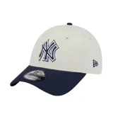Gorra New Era modelo 9FORTY de los New York Yankees, con diseño bicolor en beige y visera curva en azul marino. Cuenta con el logo bordado del equipo en el frente y el logo de la marca en el lateral.