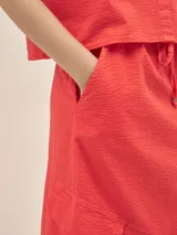 Falda larga color coral, estilo cargo, con cintura ajustable, tajo en el frente y bolsillos laterales.