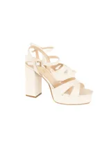 Sandalia de plataforma con tacón ancho, confeccionada en cuero color offwhite. Presenta tiras cruzadas en el empeine, pulsera ajustable al tobillo con hebilla metálica dorada y diseño de plataforma delantera.