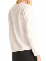 Buzo blanco de tejido liviano soft, marca Pinch. Cuello a la base realzado con una banda de micro-strass plateado. Mangas largas de corte recto con terminación de puño fino.