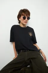 Remerón unisex verde militar de manga corta y cuello redondo, con pequeño estampado lateral en el frente y otro grande en la espalda.