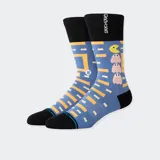 Medias Stance con diseño de Pac-Man, con laberinto amarillo sobre fondo celeste y detalles en negro en la puntera, el talón y el puño.