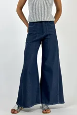 Pantalón de jean de tiro alto, corte palazzo y acabado laminado dorado.