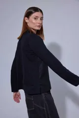 Blusa de estilo romántico con frente de lino y espalda y mangas de algodón con elastano. Presenta un diseño con mini volados en la pechera, cuello redondo y cierre frontal con botones.