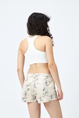 Short color crema con estampado abstracto en tonos grises, de tiro bajo y cintura elástica.