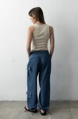 Pantalón estilo babucha color azul, de corte ancho con pretina ancha fruncida y cordones cruzados al frente. Cuenta con bolsillos cargo laterales y botamangas ajustables.