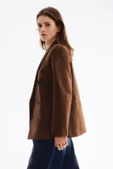 Blazer cruzado marrón con acabado cepillado, solapas de muesca, hombreras y bolsillos delanteros con solapa. Diseño con doble botonadura.