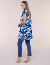 Túnica de gasa negra con estampado floral en tonos azules y blancos, cuello camisero, manga corta y cierre frontal de botones.
