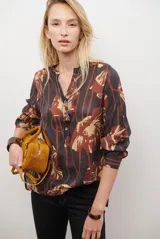 Camisa de manga larga con estampado floral en tonos marrones y negros, cuello mao y cierre frontal parcial con botones.