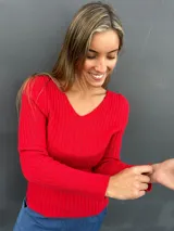 Sweater de punto acanalado color rojo, con escote en V y mangas largas con puños lisos. Diseño entallado y versátil.
