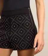 Mono corto strapless negro con estampado geométrico en blanco y bolsillos laterales.
