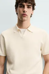 Polo de punto tejido en hilatura de algodón color azul marino, de corte regular fit, con cuello solapa y abertura frontal sin botones, manga corta y terminaciones en rib.