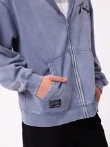 Canguro con capucha de color negro con efecto lavado, manga larga y bolsillo frontal. Presenta un estampado gráfico en la espalda con el logo de la marca y motivos abstractos en tonos violeta y amarillo.