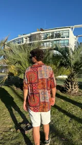 Camisa de manga corta con estampado de mosaicos en tonos rojo, naranja, azul y blanco.