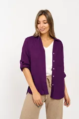 Camisa de manga larga en color violeta, con cuello clásico, cierre frontal de botones y bolsillos frontales. Presenta un diseño de corte recto con terminación redondeada en el ruedo.