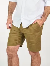 Bermuda color beige confeccionada en lino, con bolsillos laterales y traseros, y presillas para cinturón.