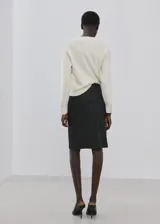 Sweater de punto color blanco marfil, con cuello redondo y manga larga, de diseño clásico y holgado.