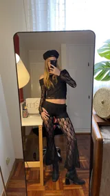 Top de encaje negro con escote bardot y mangas largas. Presenta un diseño ajustado al cuerpo con acabado delicado.