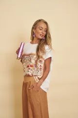 Blusa blanca de manga corta y corte holgado, con panel frontal de seda con estampado botánico y floral en tonos marrones y rojos.