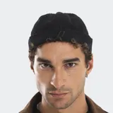 Beanie estilo docker de pana negra, con ajuste posterior y logo bordado en la parte frontal.