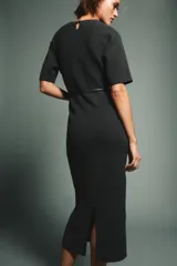 Vestido midi de punto en color gris oscuro, con cuello redondo, manga corta y detalle de abertura con botón en la espalda. Incluye un cinturón fino ajustable en la cintura.