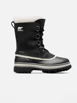Bota de nieve Sorel modelo Caribou, con diseño impermeable de caña media. Presenta una parte superior de nubuck negro con costuras selladas, cordones frontales y una base de goma vulcanizada resistente. Incluye un forro interior de fieltro y detalle de pelo sintético en el borde superior.
