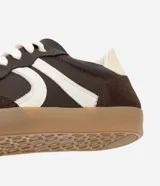 Championes de estilo retro inspirados en calzado de fútbol, confeccionados en poliuretano color verde menta con detalles laterales en rosado. Presentan suela plana de goma color caramelo y cierre mediante cordones al tono.