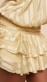 Vestido corto marrón con estampado de lunares beige, diseño sin mangas, cuello halter y falda con volantes escalonados.