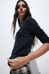 Remera de punto suave, entallada, de manga larga con cuello redondo y bajo recto.
