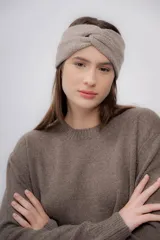 Vincha de lana color beige, tejida a mano, con diseño trenzado en el frente.