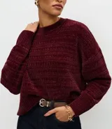 Suéter de punto chenille color gris oscuro, con cuello redondo alto, textura acanalada y puños ajustados.