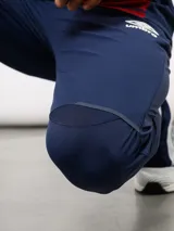 Pantalón de entrenamiento Umbro del Club Nacional de Football, color azul marino. Presenta un diseño técnico con paneles reforzados en la zona de las rodillas, escudo del club en el muslo derecho y logo de la marca en el izquierdo.