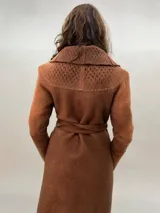 Tapado largo color marrón de lana merino afieltrada, con cuello grande, lazos para ajustar en la cintura, bolsillos laterales y puños calados.