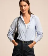 Camisa de tricolina con estampado de rayas verticales en hilo teñido, cuello solapa, abotonado frontal y mangas largas con puños abotonados.