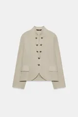 Blazer de cuello redondo con escote en pico, manga larga y cierre frontal con botones metálicos. Presenta falsos bolsillos con solapa en el delantero y un diseño estructurado.